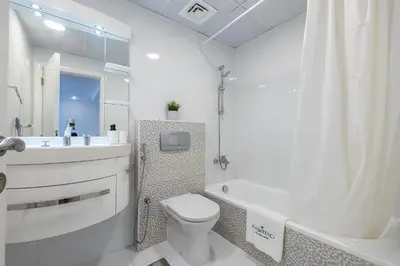 a white bathroom with a toilet and a tub and a sink at 1BDR Apartment I Close To Metro I Marina Diamond 4 in Dubai