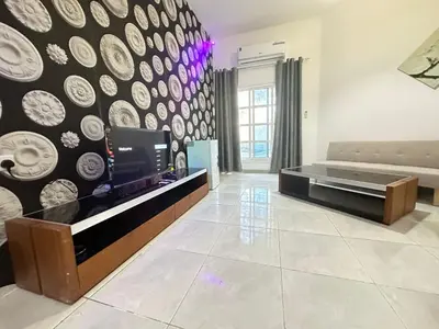 a living room with a tv and a wall with plates at Relaxing Private Rooms in Compound Housing near Burj Alarab Villa 124 in Dubai