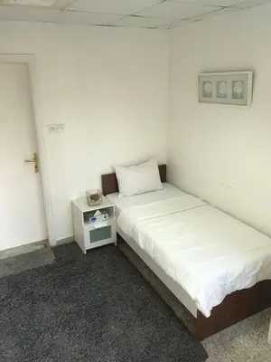 a room with two beds and a night stand at Relaxing Private Rooms in Compound Housing near Burj Alarab Villa 124 in Dubai
