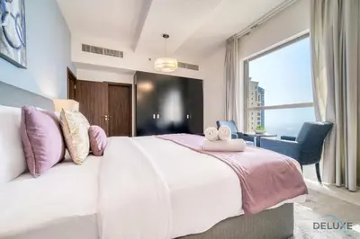 a bedroom with a large bed and a large window at Exquisite 2BR At Shams 1 JBR by Deluxe Holiday Homes in Dubai