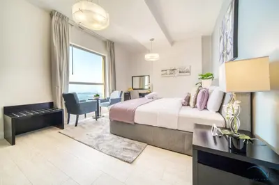 a hotel room with a large bed and a desk at Exquisite 2BR At Shams 1 JBR by Deluxe Holiday Homes in Dubai