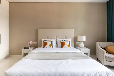 a bedroom with a large white bed with pillows at Frank Porter - Damac Cour Jardin in Dubai