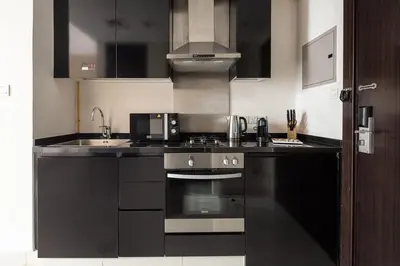a kitchen with a stove and a microwave at Frank Porter - Damac Cour Jardin in Dubai