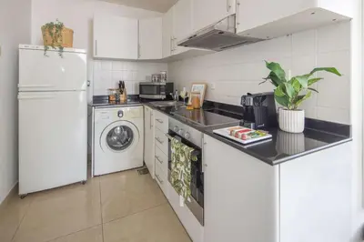 a kitchen with a white refrigerator and a washer and dryer at Frank Porter - Yach Bay in Dubai