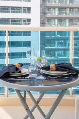 a white table with glasses and plates and napkins at Frank Porter - Yach Bay in Dubai