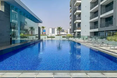 a large blue swimming pool next to a building at Frank Porter - Sunrise Legend in Dubai