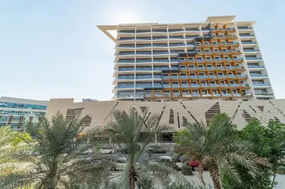 a large building with palm trees in front of it at Frank Porter - Sunrise Legend in Dubai
