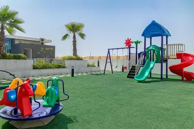 a park with a playground with a slide and swings at Frank Porter - Sunrise Legend in Dubai