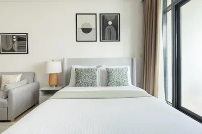 a bedroom with a large bed and a chair at Frank Porter - Sunrise Legend in Dubai