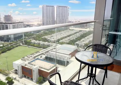 a balcony with a table and a view of a tennis court at Fully Furnished 1 Bed in Sobha Creek Vista hosted by Desert City Stays in Dubai