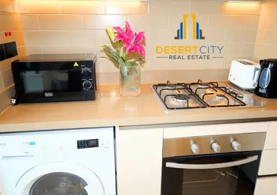 a kitchen with a microwave and a washing machine at Fully Furnished 1 Bed in Sobha Creek Vista hosted by Desert City Stays in Dubai