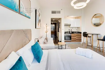 a living room with two beds and a kitchen at Sparkle Tower - Studio, Dubai Marina in Dubai