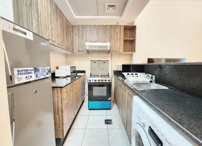 a small kitchen with a sink and a refrigerator at RH- Relaxing Studio, Downtown with private balcony, walk away from Burj Khalifa in Dubai