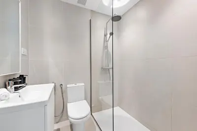 a white bathroom with a toilet and a shower at Unique Dubai Marina Studio, near Jumeirah Beach, Mall and Metro in Dubai