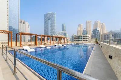 a swimming pool on the roof of a building with a city skyline at Unique Dubai Marina Studio, near Jumeirah Beach, Mall and Metro in Dubai