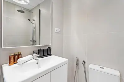 a white bathroom with a sink and a mirror at Unique Dubai Marina Studio, near Jumeirah Beach, Mall and Metro in Dubai