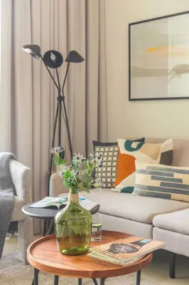 a living room with a couch and a table with a vase at Frank Porter - Downtown Views 2 in Dubai
