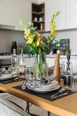 a dining room table with plates and a vase of flowers at Frank Porter - Downtown Views 2 in Dubai