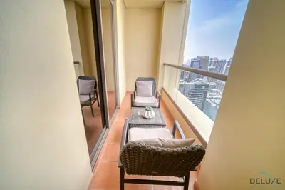 a balcony with chairs and a table on a building at Stylish 2BR At Shams 1 JBR by Deluxe Holiday Homes in Dubai