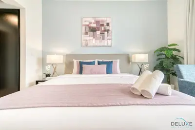 a bedroom with a large white bed with two lamps at Stylish 2BR At Shams 1 JBR by Deluxe Holiday Homes in Dubai