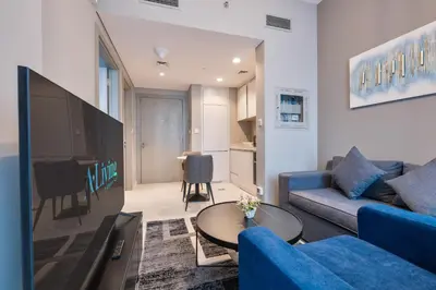 a living room with a blue couch and a table at ALiving Luxury 1BR with Canal View I Near Burj Khalifa & Dubai Mall I Zada Tower, 2613 in Dubai