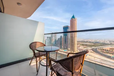 a balcony with chairs and a table and a view of a city at ALiving Luxury 1BR with Canal View I Near Burj Khalifa & Dubai Mall I Zada Tower, 2613 in Dubai