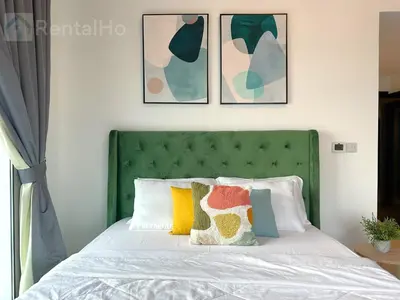 a bed with a green headboard and pillows on it at Luxury Stop w/ BoHo Design & Sea View in Marina in Dubai