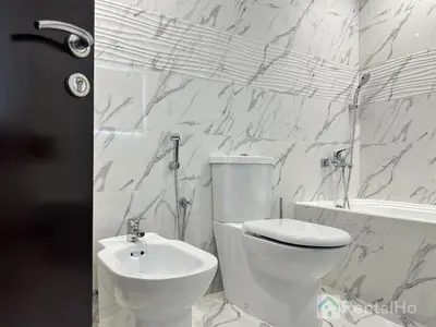a white bathroom with a toilet and a sink at Luxury Stop w/ BoHo Design & Sea View in Marina in Dubai