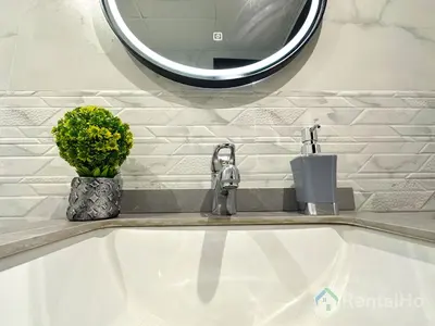a bathroom sink with a mirror and a vase of flowers at Luxury Stop w/ BoHo Design & Sea View in Marina in Dubai