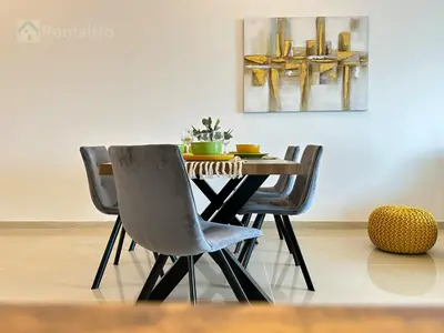 a dining room table with two chairs and a painting at Luxury Stop w/ BoHo Design & Sea View in Marina in Dubai