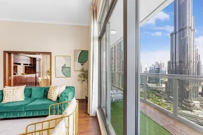 a living room with a green couch and a large window at Durrani Homes - Alluring 5BR Penthouse with Burj Khalifa and Fountain View in Dubai
