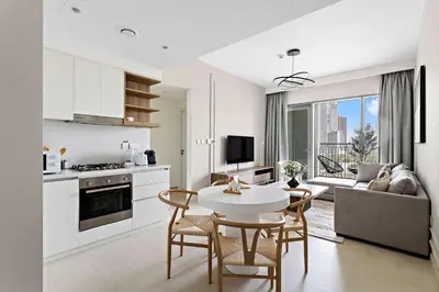 a kitchen and living room with a table and chairs at Silkhaus luxurious 1BDR in new tower with pool & gym in Dubai