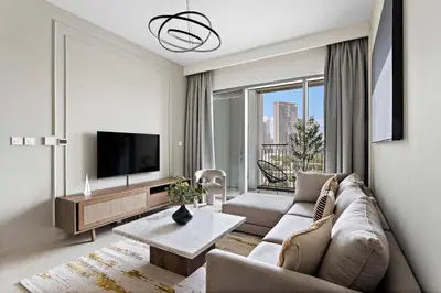a living room with a couch and a tv at Silkhaus luxurious 1BDR in new tower with pool & gym in Dubai