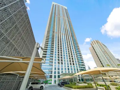 a tall building with a car parked in front of it at Silkhaus modern & chic 1BDR in new tower with pool & gym in Dubai