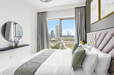 a bedroom with a bed and a large window at Silkhaus modern & chic 1BDR in new tower with pool & gym in Dubai