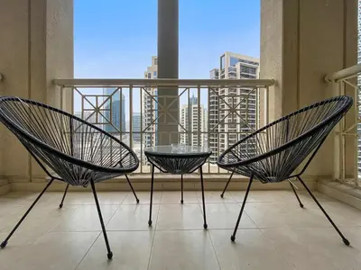two chairs and a table on a balcony with a view at Silkhaus beautiful studio in Downtown near Burj Khalifa in Dubai