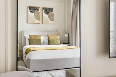 a bedroom with a white bed and a mirror at Silkhaus beautiful studio in Downtown near Burj Khalifa in Dubai