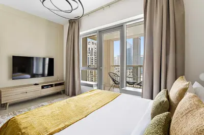 a bedroom with a large bed and a television at Silkhaus beautiful studio in Downtown near Burj Khalifa in Dubai