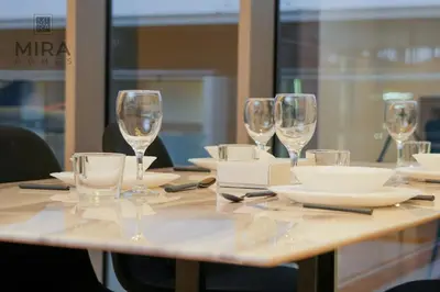 a table with wine glasses and plates on it at Mira Holiday Homes - Fully furnished 1 bedroom in Bluewater in Dubai