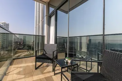 a balcony with a table and chairs on a building at Stunning 1 Bedroom Apartment - Regina Tower - JVC in Dubai