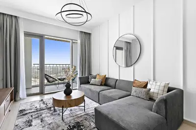 a living room with a couch and a mirror at Silkhaus lavish 1BDR in new tower with pool & gym access in Dubai