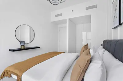 a bedroom with a bed with a mirror on the wall at Silkhaus lavish 1BDR in new tower with pool & gym access in Dubai
