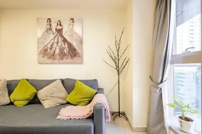 a living room with a gray couch with yellow pillows at Most enjoyable 2BR apartment in Dubai marina in Dubai