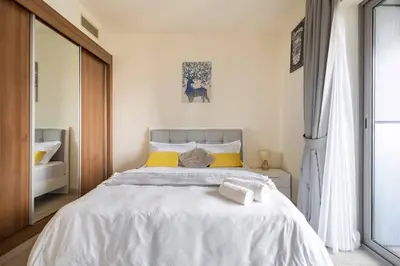 a bedroom with a large white bed with yellow pillows at Most enjoyable 2BR apartment in Dubai marina in Dubai