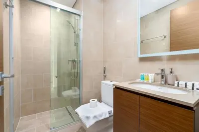a bathroom with a shower and a sink and a toilet at 10min from Burj Khalifa - Sobha Creek Vistas Réservé in Dubai