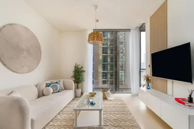 a living room with a couch and a tv at 10min from Burj Khalifa - Sobha Creek Vistas Réservé in Dubai