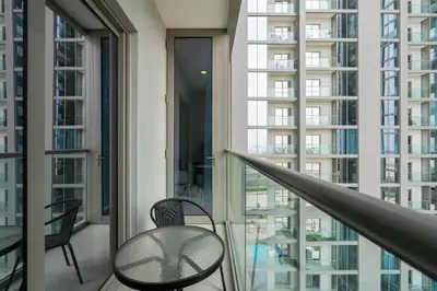 a balcony with a table and chairs and windows at 10min from Burj Khalifa - Sobha Creek Vistas Réservé in Dubai