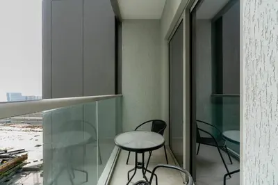 two chairs and a table in a room with a window at 10min from Burj Khalifa - Sobha Creek Vistas Réservé in Dubai