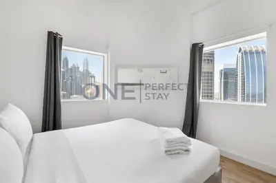 a white bed in a white room with a sign at Stunning Lake View - Height Floor - Furnished 1BR in Dubai