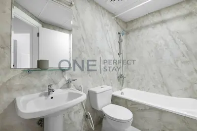 a bathroom with a white toilet and a sink at Stunning Lake View - Height Floor - Furnished 1BR in Dubai